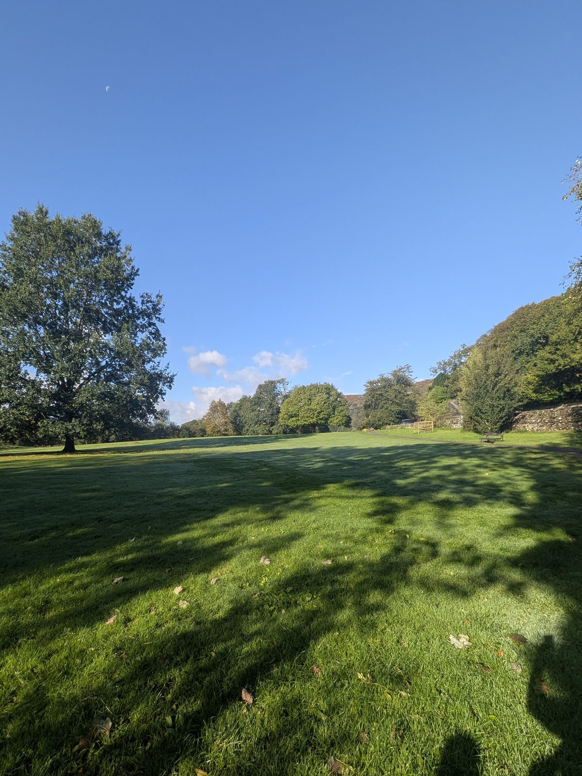 The open lawn of Borrans Park, Ambleside, under a blue sky
