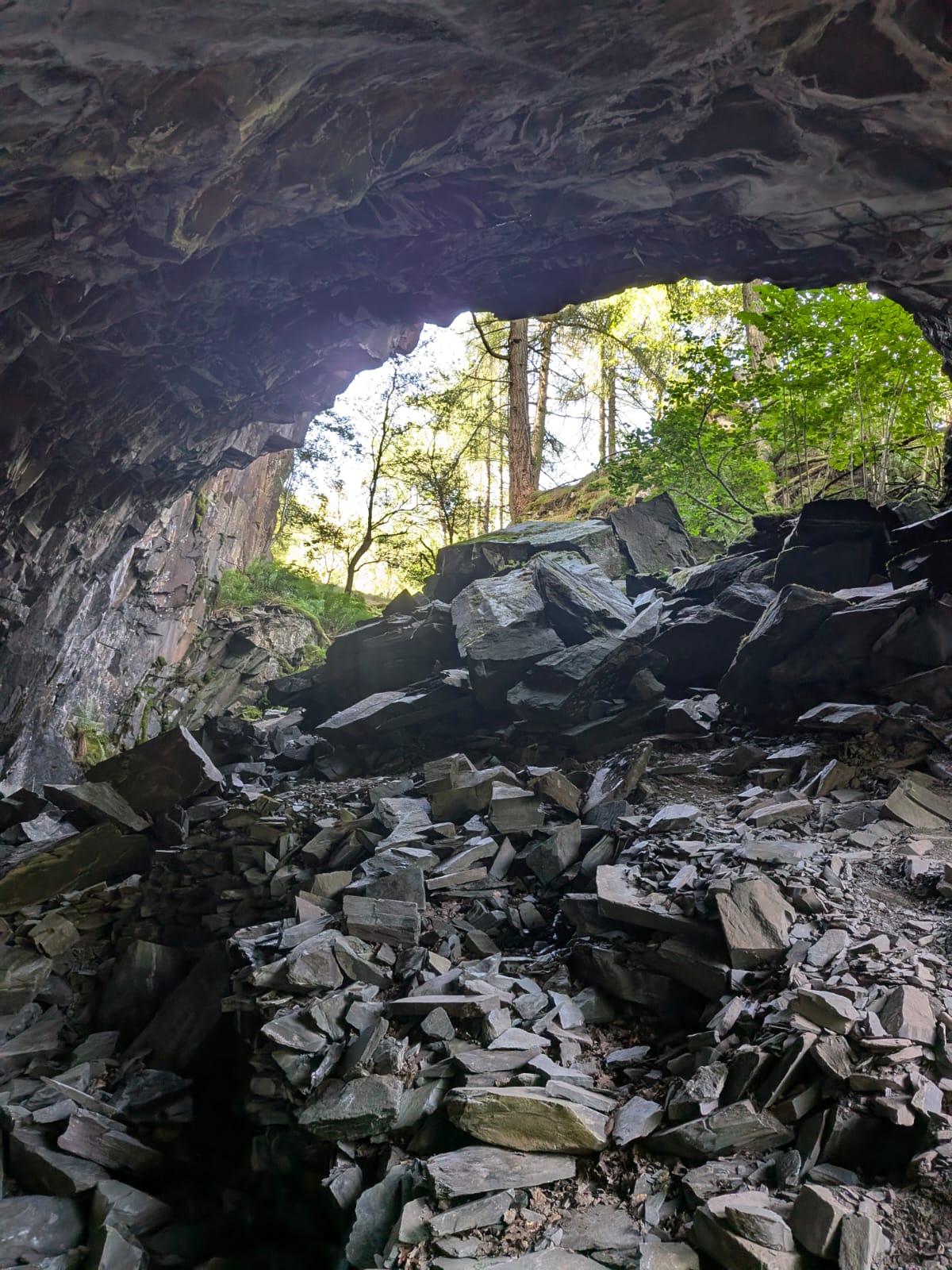 The mouth of the cave in Borrowdale seen from within, with piled slate blocks on the floor