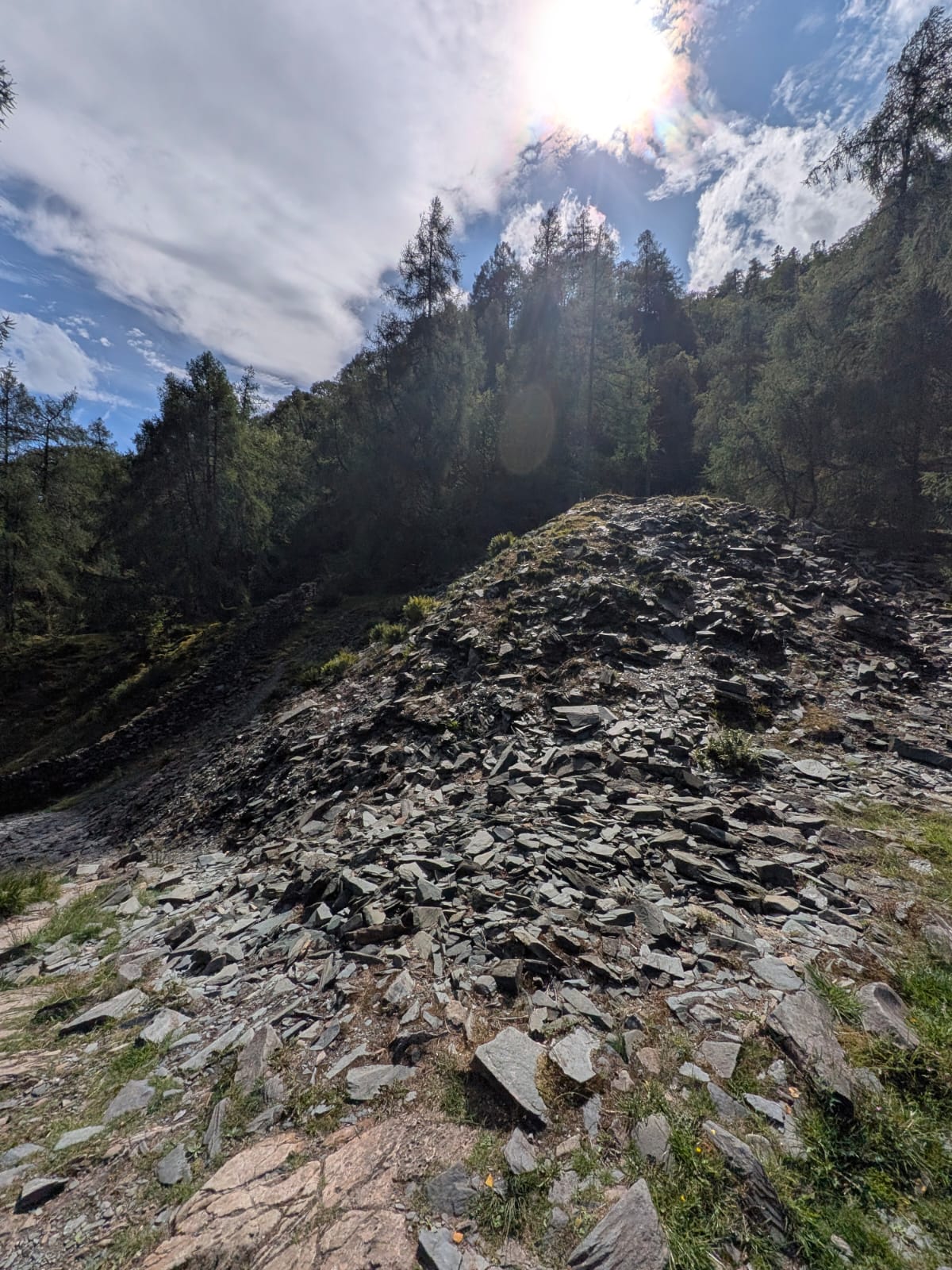 The slate spoil slope of the abandoned quarry beside the riverside path in Borrowdale