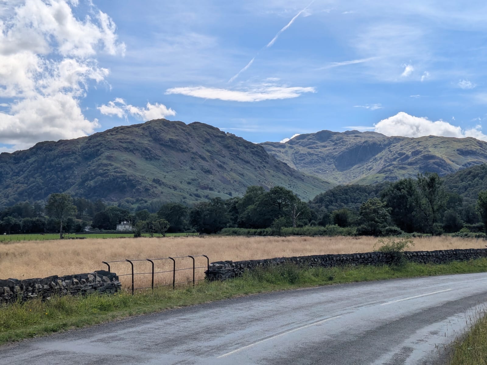 The B5289 valley road heading south towards Rosthwaite between drystone walls, with the Borrowdale fells ahead