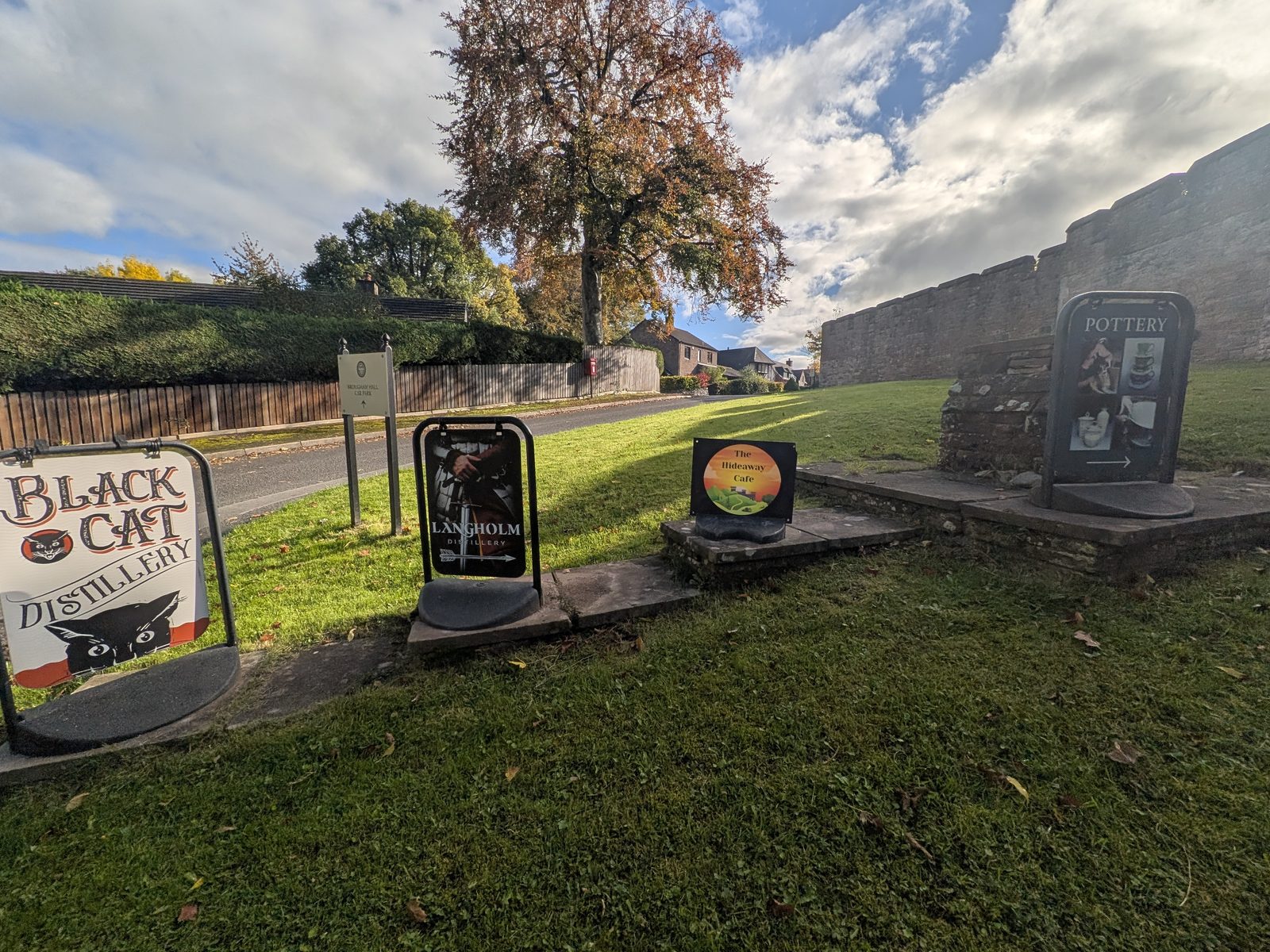 A-boards for Black Cat Distillery and other makers on the grass by the Brougham Hall car park sign