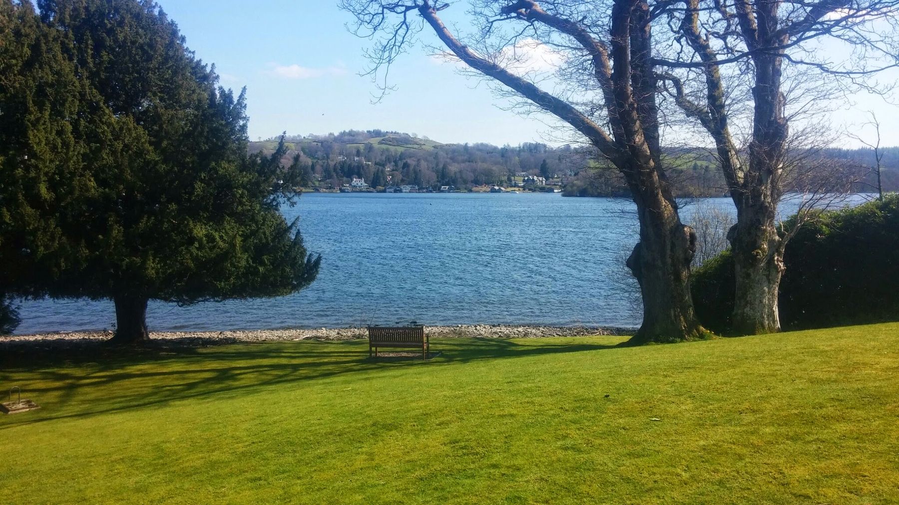 Lawn and shingle shore on the quiet western side of Windermere near Far Sawrey, Lake District