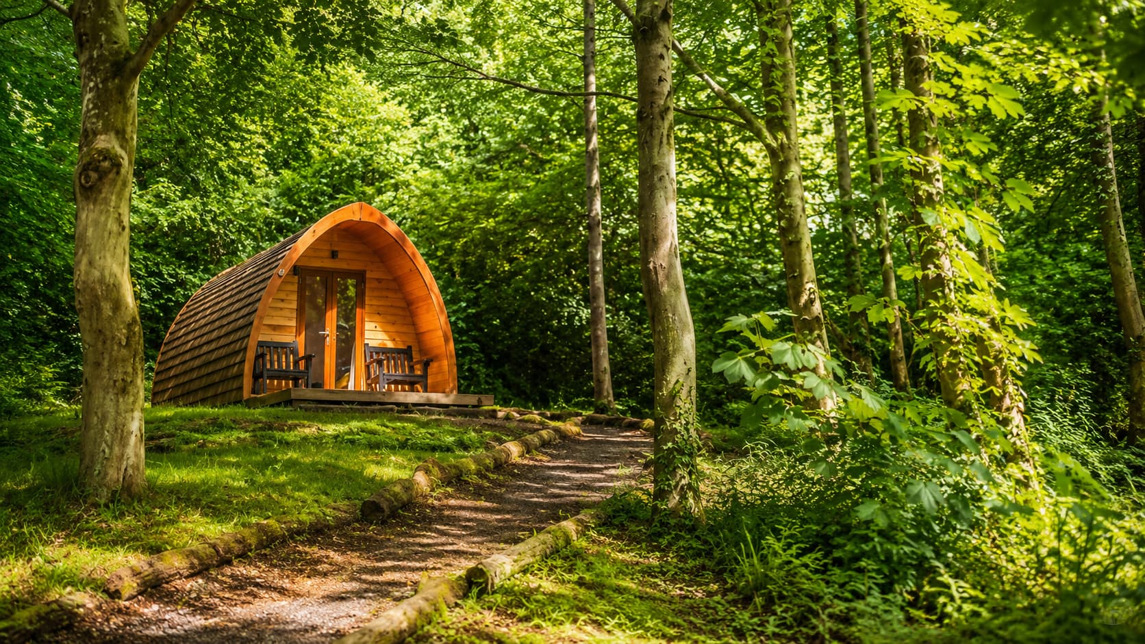 A glamping cabin with a private hot tub on a deck looking out over the Lake District fells