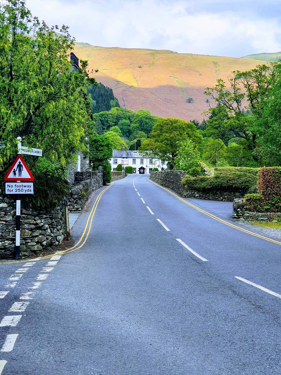 The road into Grasmere village with the fells behind