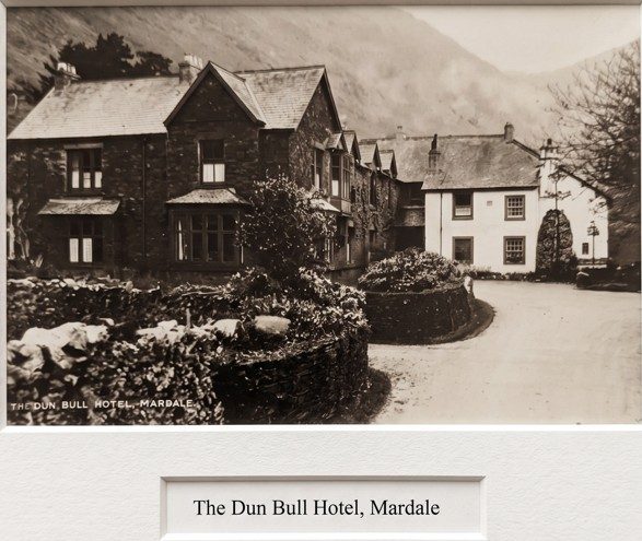 Old sepia photograph of the Dun Bull Hotel at Mardale: a two-storey stone inn with a whitewashed wing, behind a low garden wall and hedge, captioned 'The Dun Bull Hotel, Mardale'