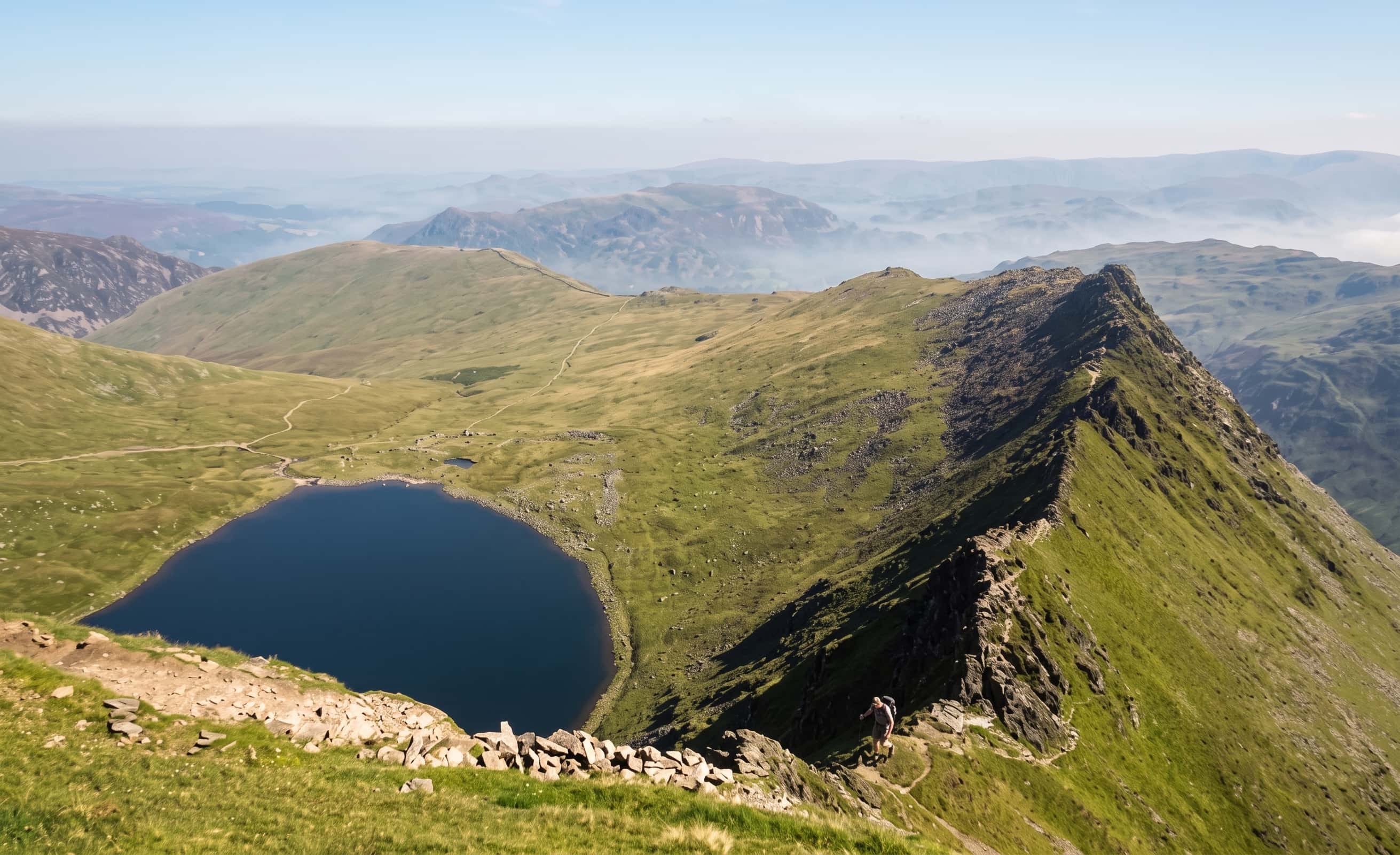 The knife-edge of Striding Edge leading to the summit of Helvellyn above Red Tarn, Lake District