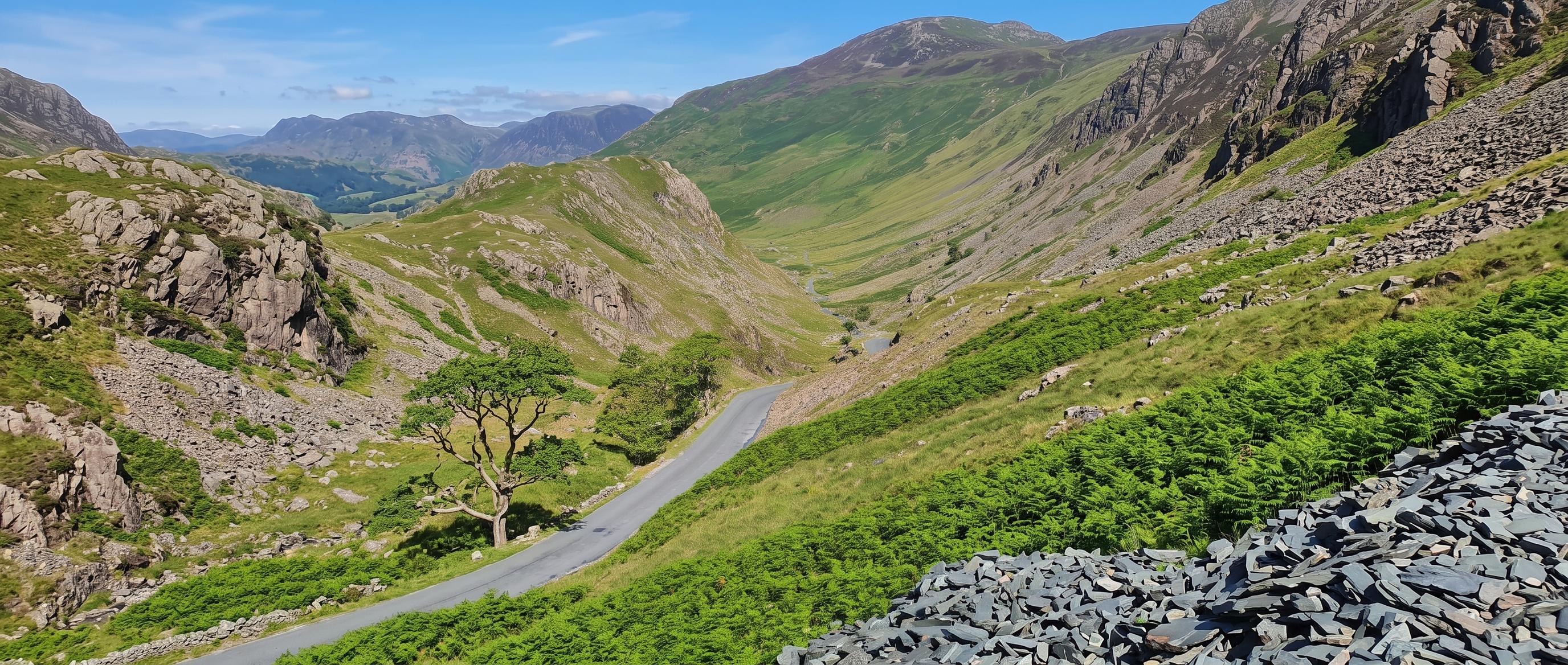 The Honister Pass road winding down the valley from near the summit, slate spoil in the foreground