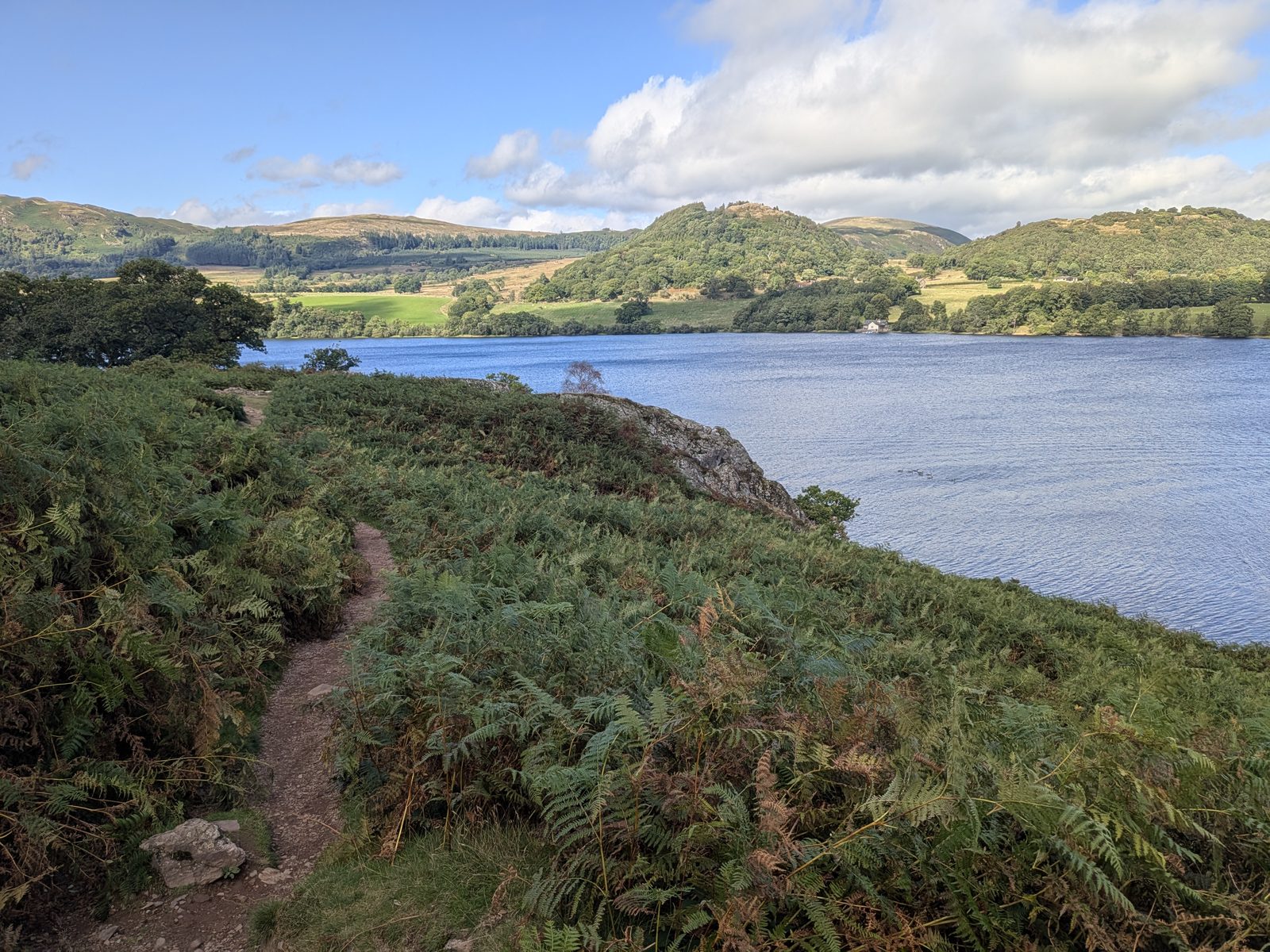 The path through bracken with Kailpot Crag ahead and fells across the water
