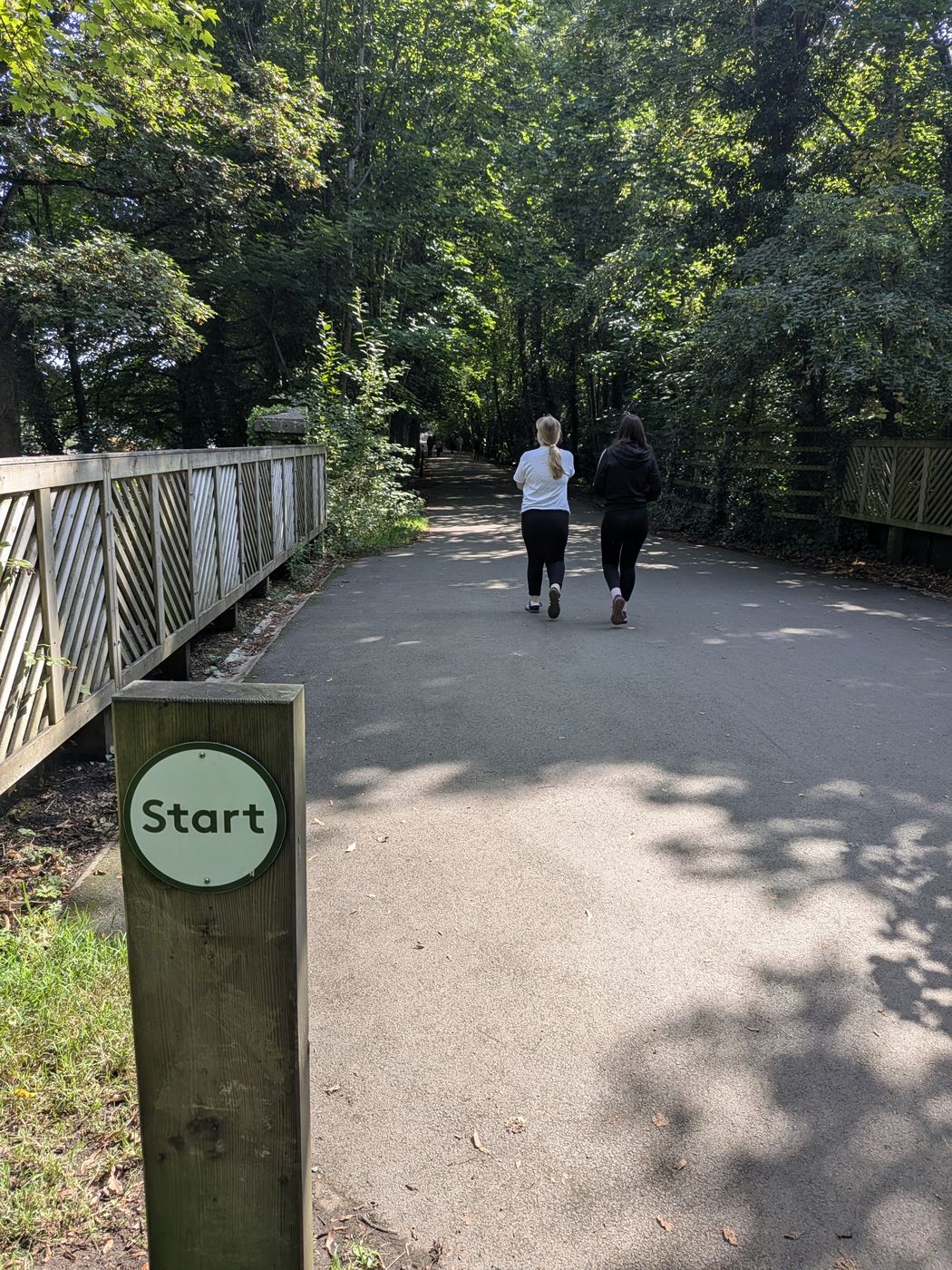 The Keswick parkrun start post beside the surfaced path at the Keswick end of the railway trail