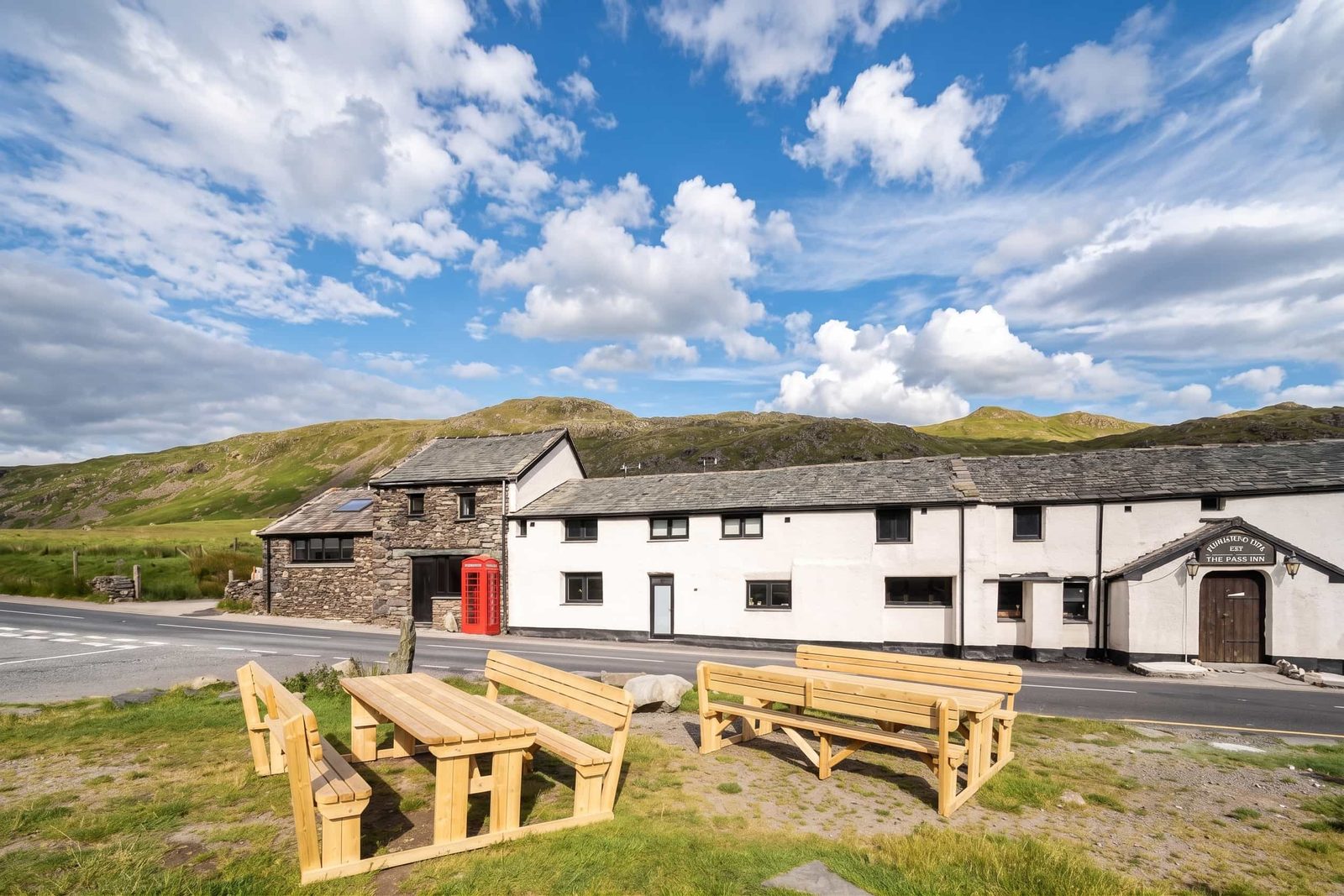 The whitewashed Kirkstone Pass Inn building beside the A592 at the summit, with benches outside