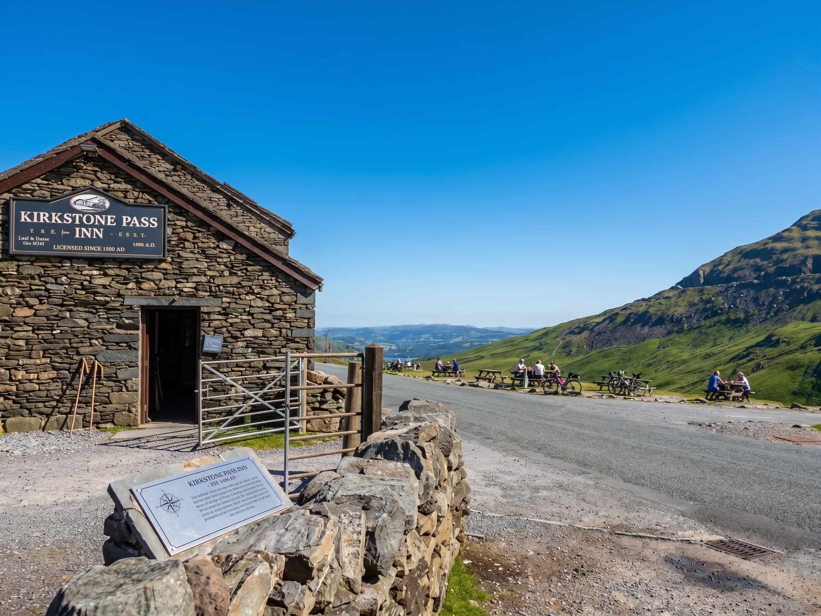 The stone gable of the Kirkstone Pass Inn and the gate at the summit, with the fells and the valley beyond