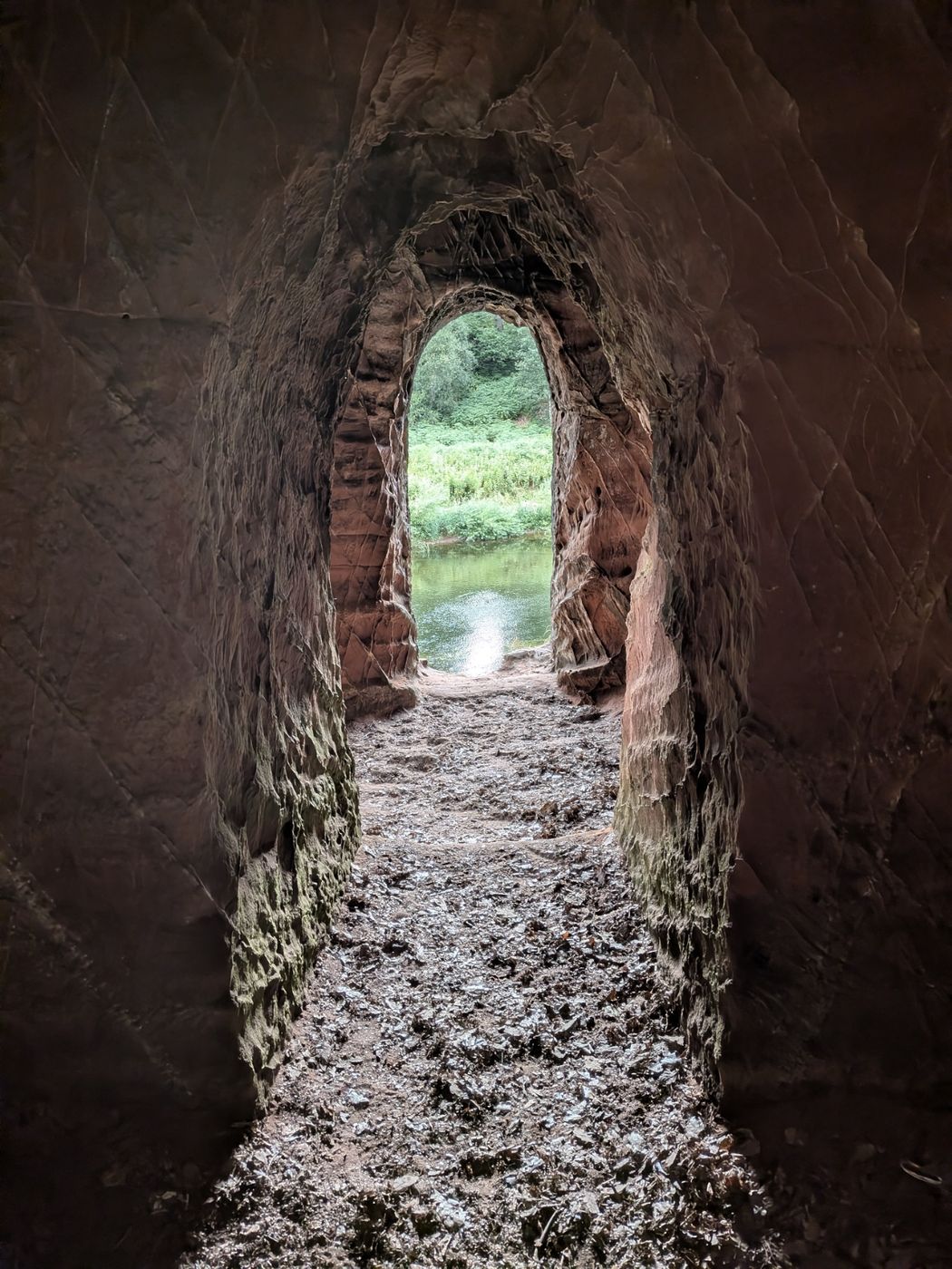 A carved arch inside Lacy's Caves framing the River Eden, near Kirkoswald