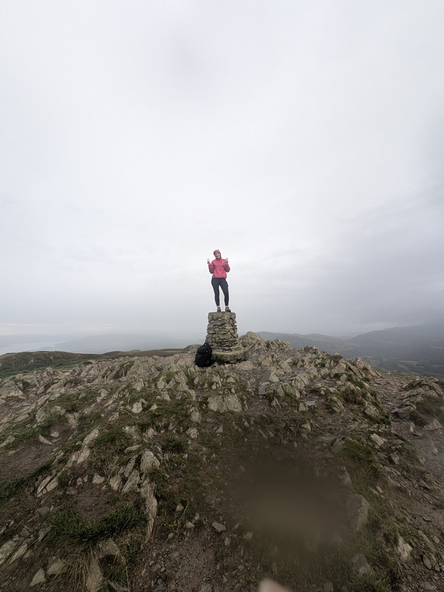 Ellie on the trig point on the summit of Loughrigg Fell