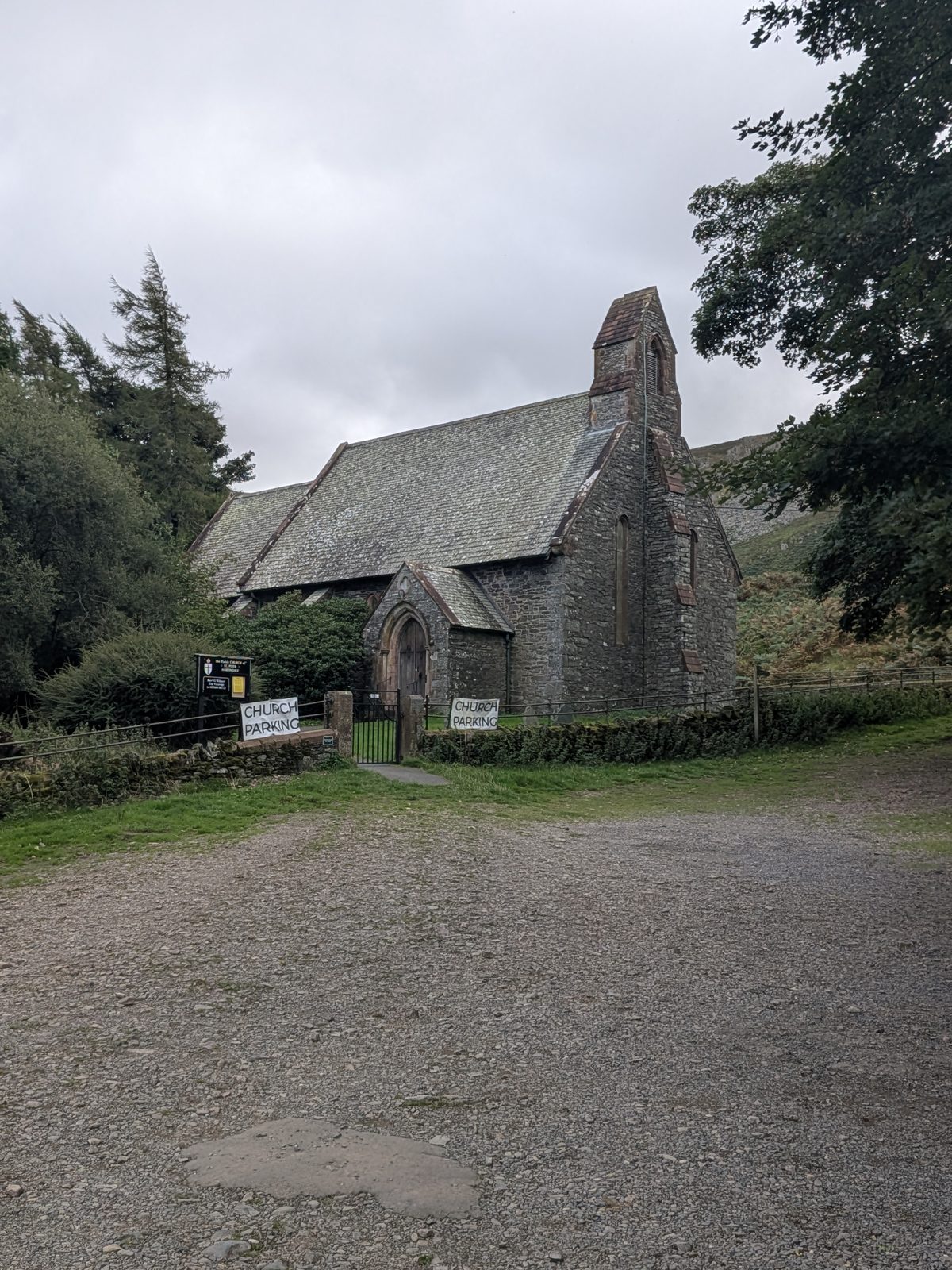 St Peter's Church, Martindale, from the parking area, with two hand-painted CHURCH PARKING boards at the gate