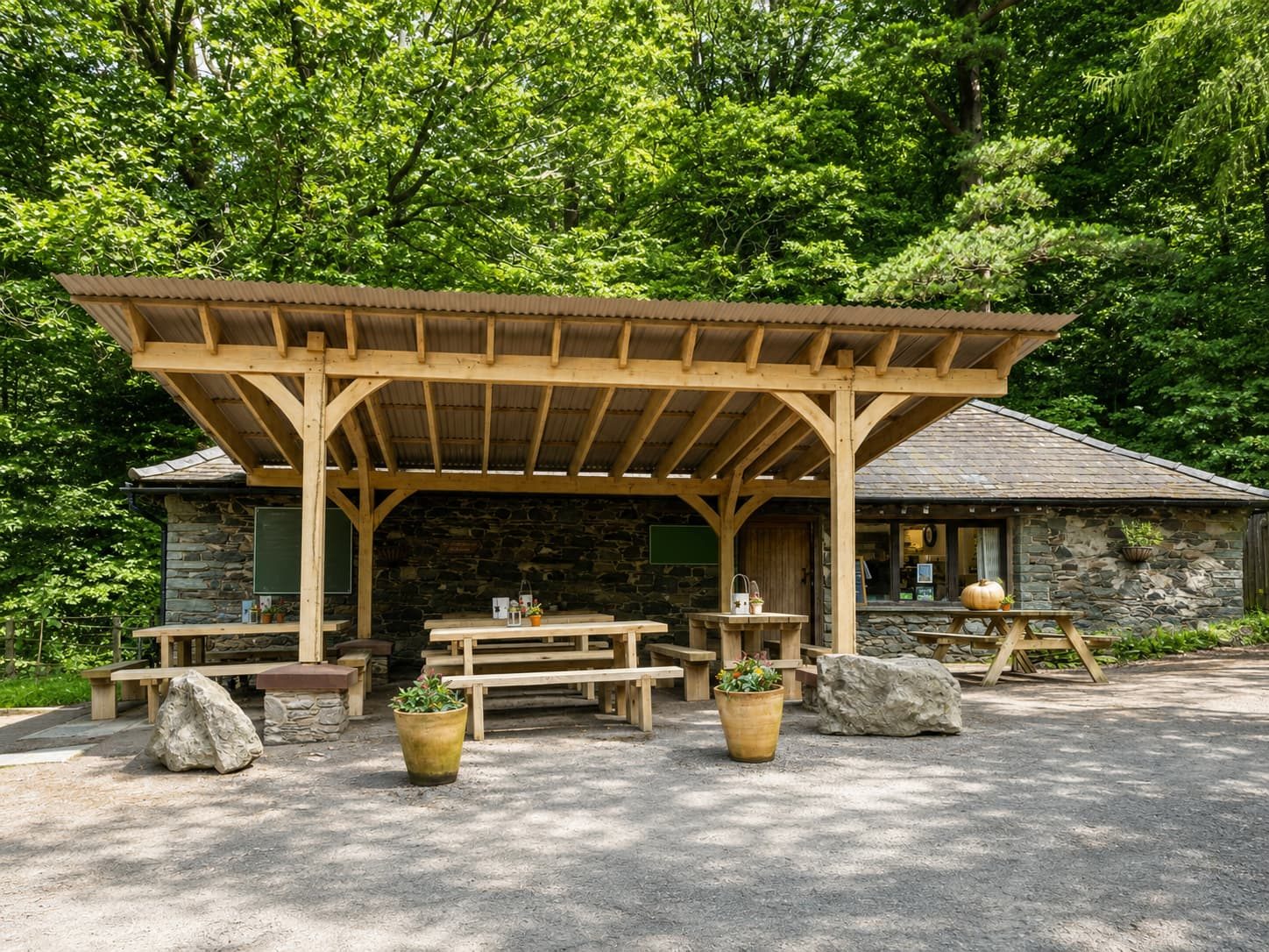 The Old Sawmill Tearoom in the Dodd Wood car park opposite Mirehouse — a timber picnic shelter in front of the old stone sawmill