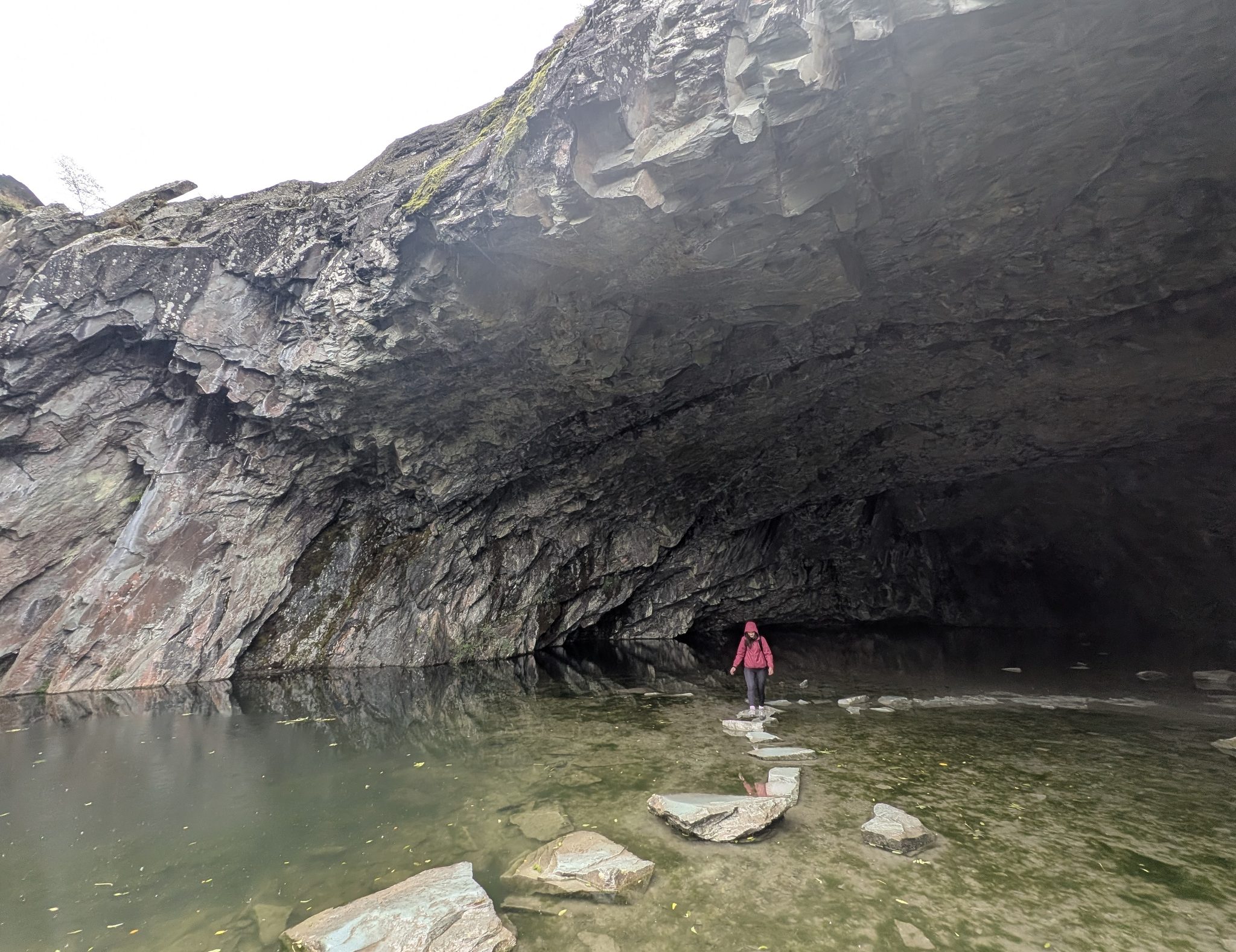 Ellie crossing the stepping stones over the pool inside Rydal Cave