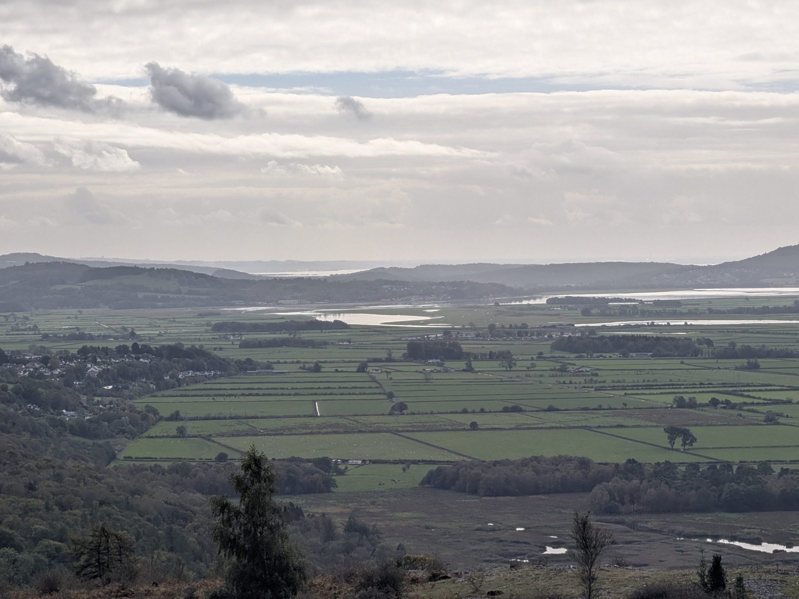 The view from the first viewpoint on Scout Scar over flat fields to the bay and the hills of Arnside and Silverdale