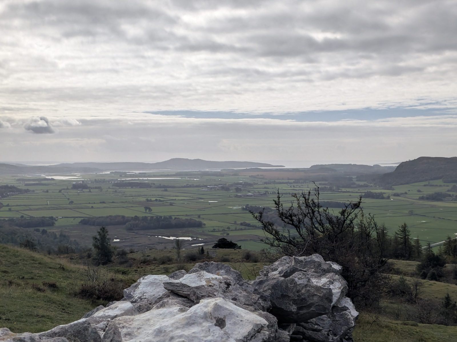 Limestone rocks in the foreground at the first viewpoint on Scout Scar, with the bay beyond