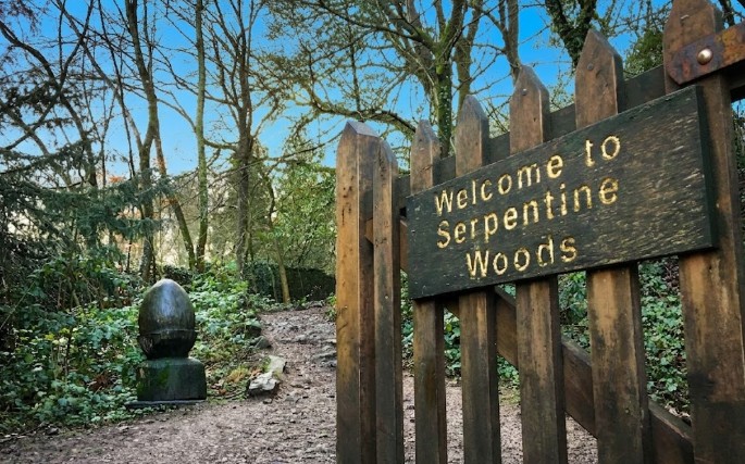 The Welcome to Serpentine Woods gate and carved acorn at the entrance to the woods, Kendal, Lake District