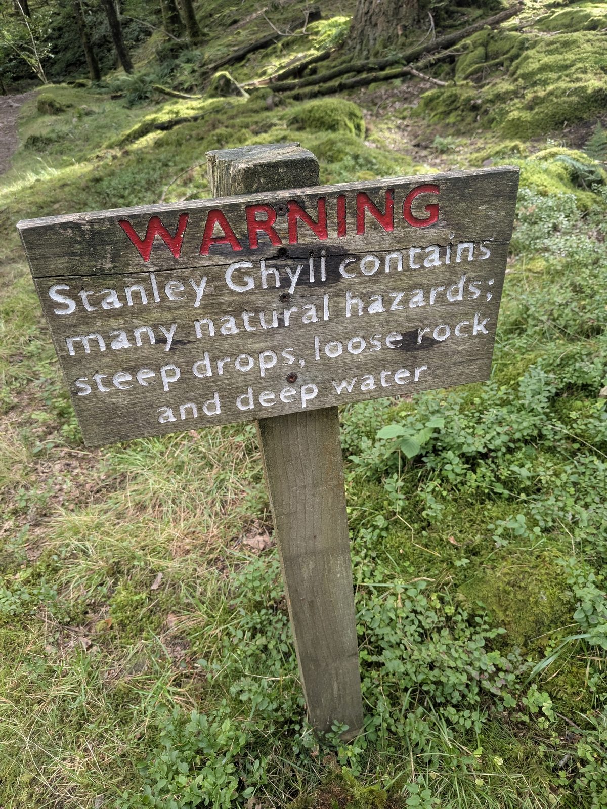 Warning post at Stanley Ghyll listing steep drops, loose rock and deep water, Eskdale
