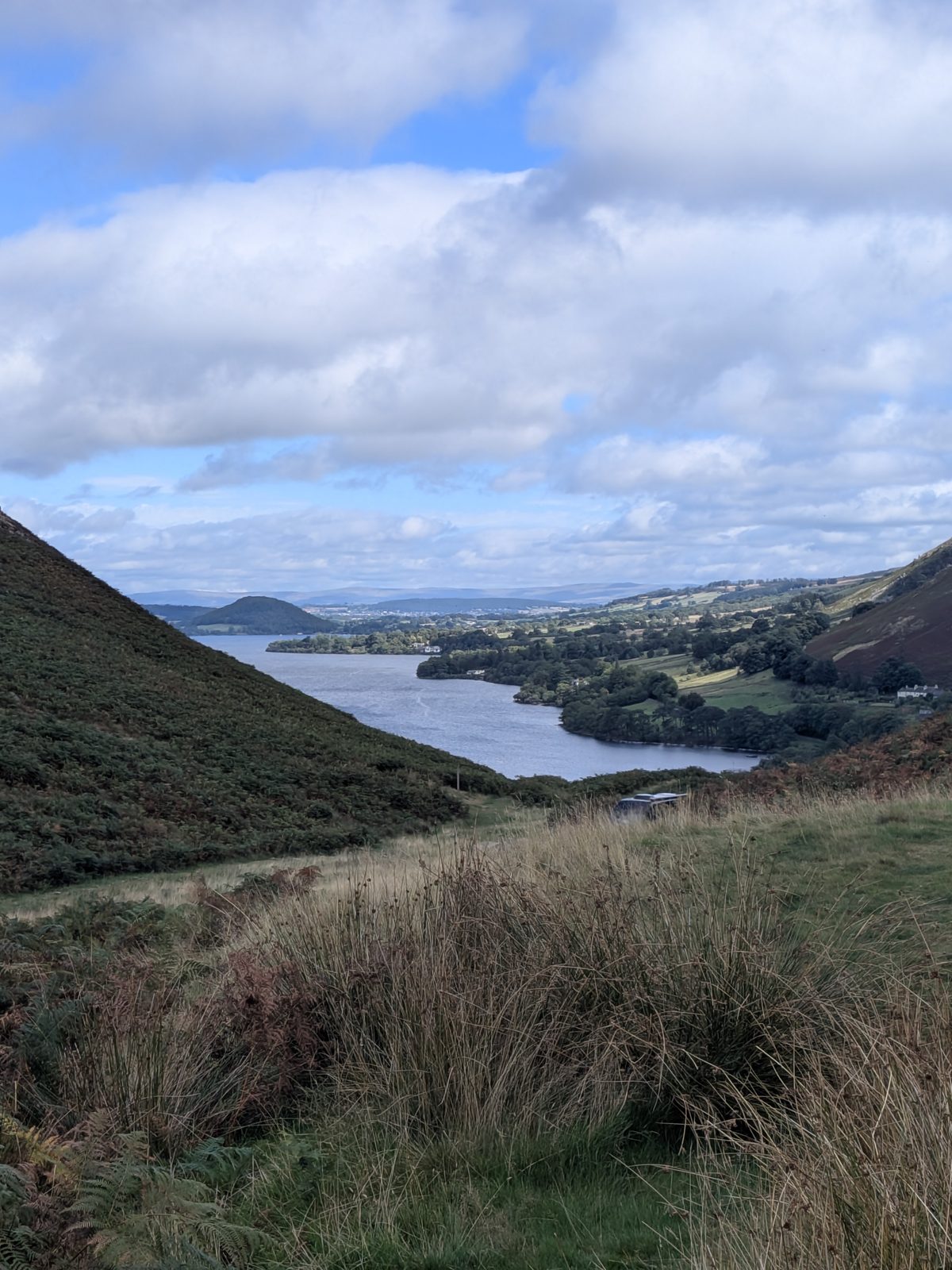 Ullswater from the Martindale hillside, looking down the length of the lake to a wooded conical hill at the far end