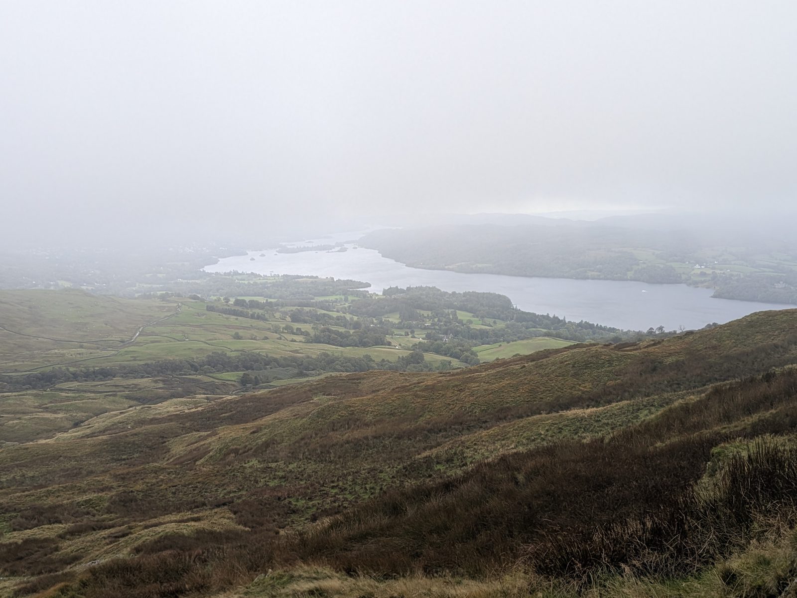 Windermere under a low cloud base, beyond brown hillside