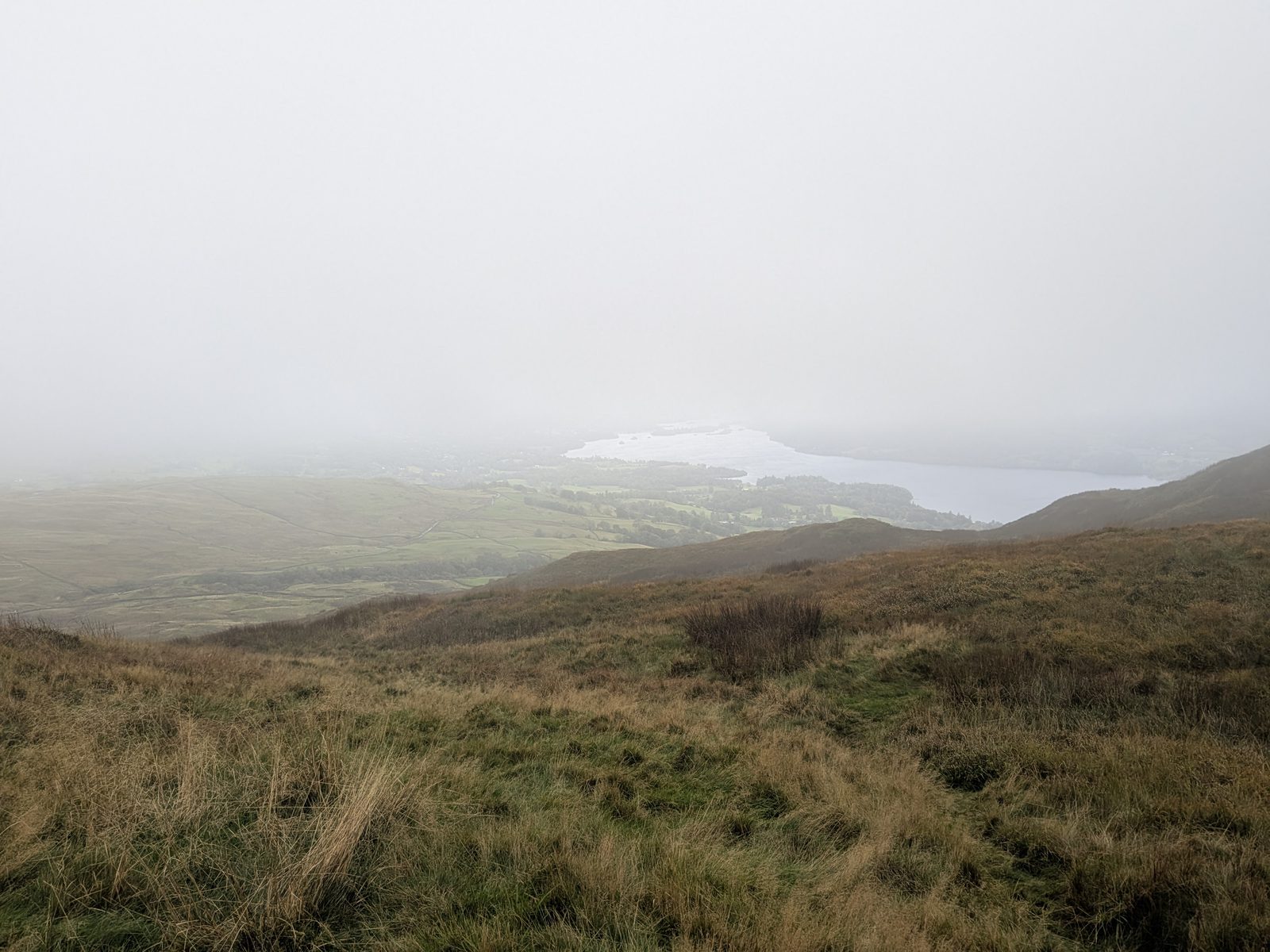 Windermere almost lost in cloud, beyond brown hillside