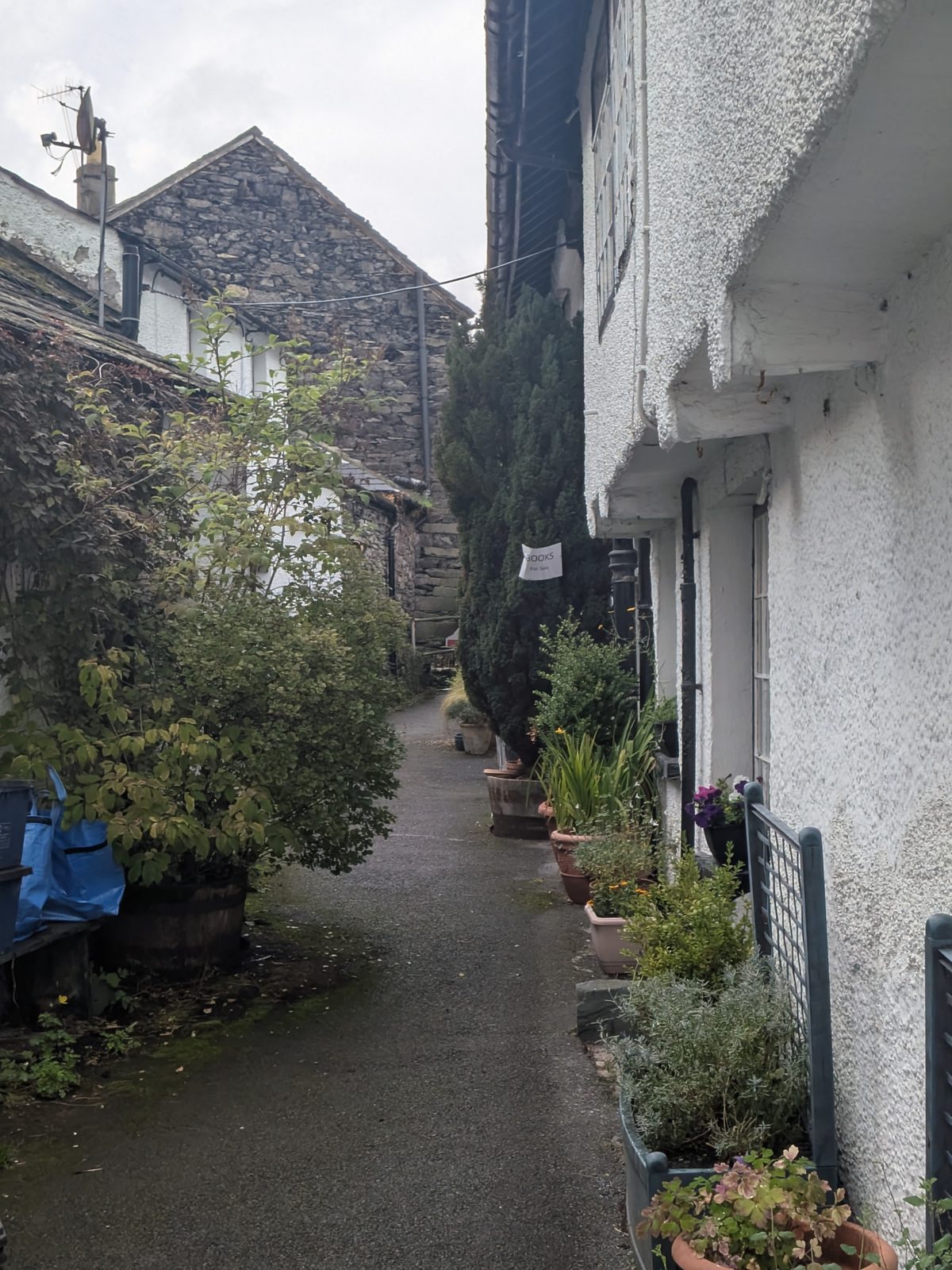 Whitewashed cottage walls and planters on a lane in Hawkshead